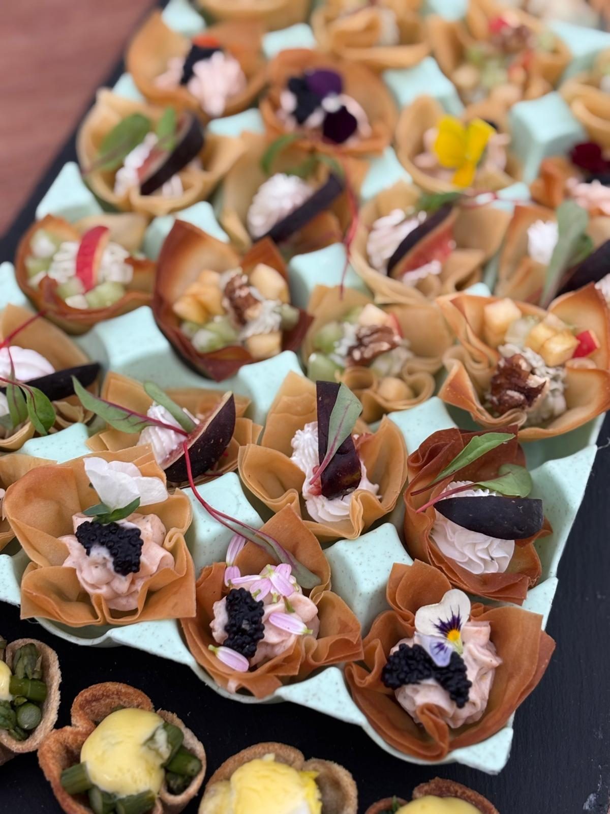 A board of crostini topped with smoked salmon, prosciutto and whipped cheese.