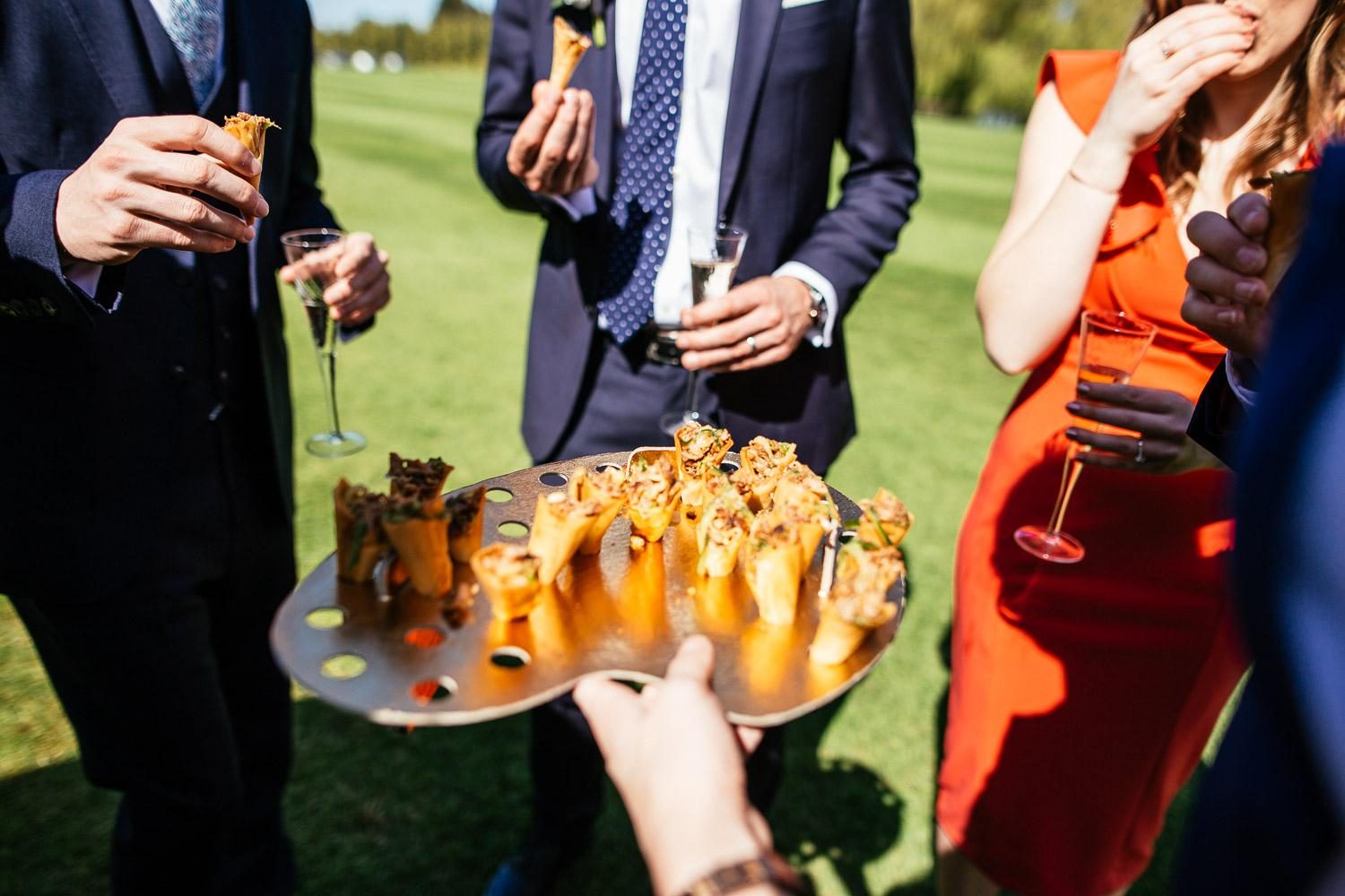 Guests enjoying canapes together at an outdoor private celebration.