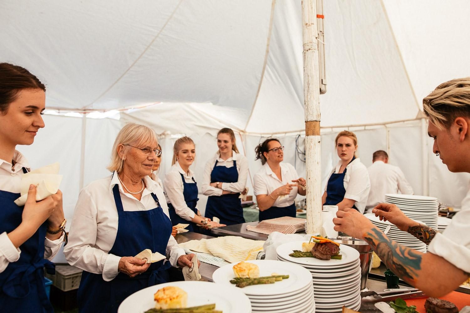 Sally and the team plating food together in the event kitchen.