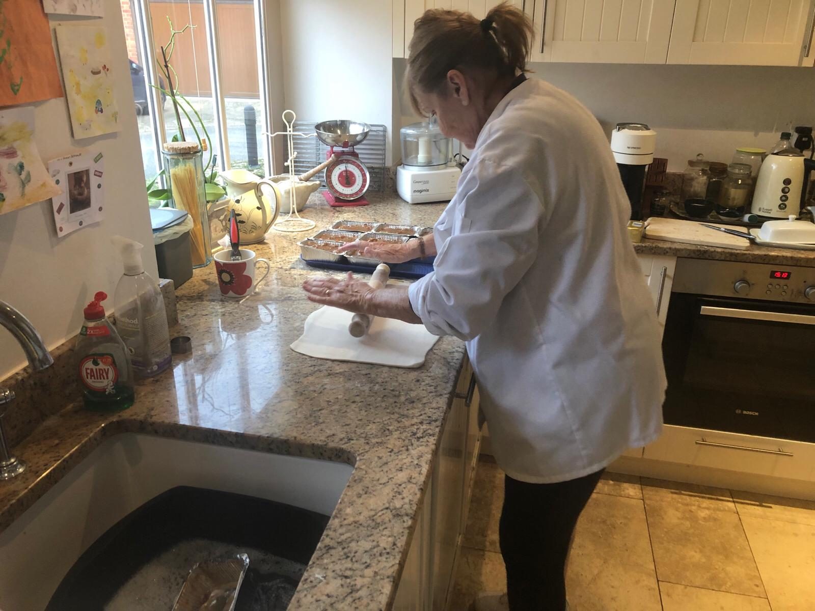 Sally hand-rolling pastry in the kitchen for a batch of homemade pies.
